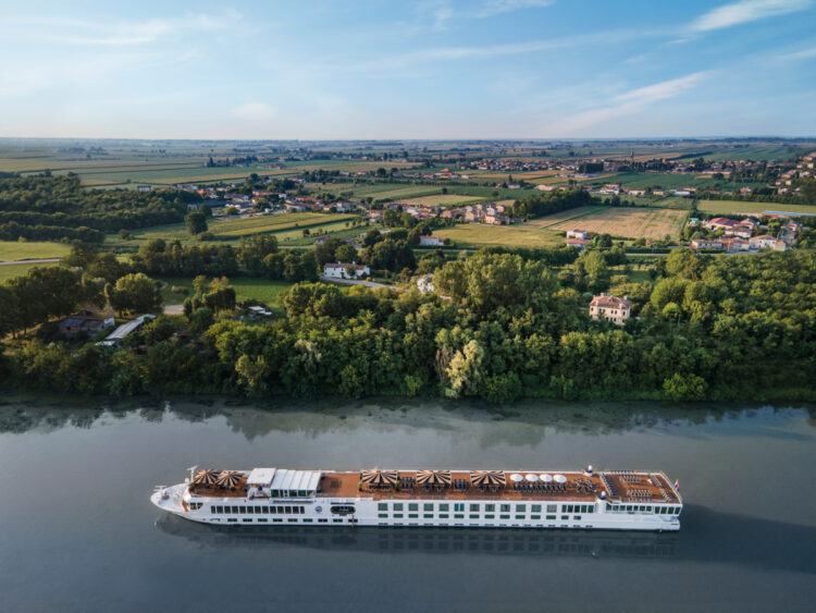 Uniworld luxury river cruise ship sailing through the Italian countryside along the Po River