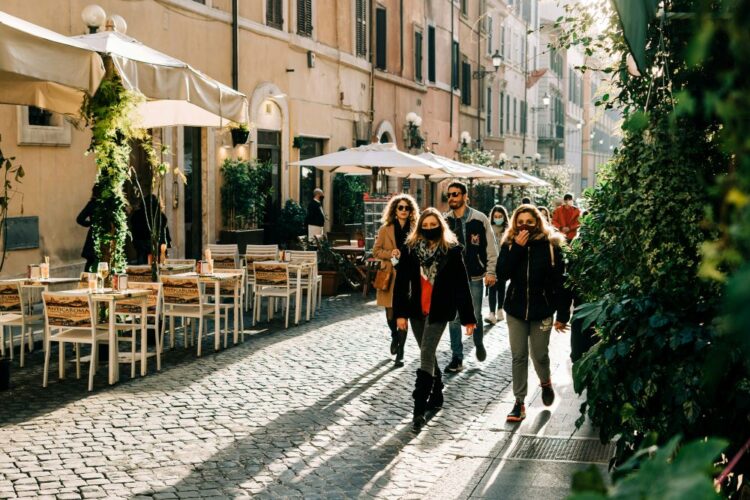Women exploring a cobblestone street cafe on a girlfriend trip around the world in Europe.