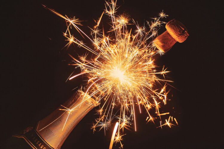 A bottle of Champagne popping as sparklers flame, perfect for any or our best 35th birthday destinations.