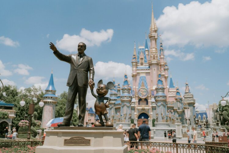 Walt Disney and Mickey Mouse statue at Magic Kingdom with Cinderella Castle in background – luxury Disney vacation planning