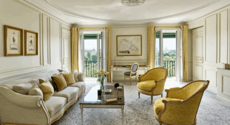 Elegant hotel suite with classic French decor, yellow armchairs, and garden views