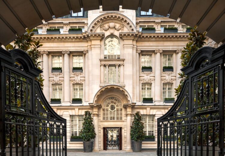 Elegant stone building with classical architecture framed by wrought iron gates