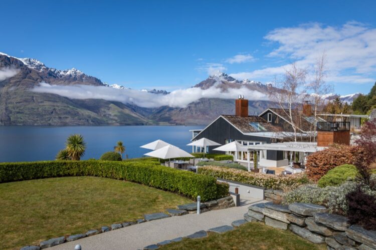Lakeside luxury lodge with snow-capped mountains in the background