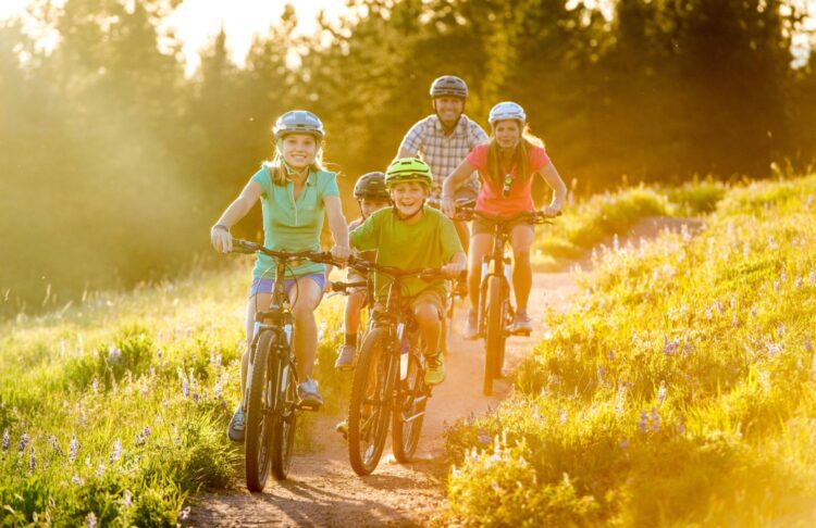 Family biking on a mountain trail during summer at Park Hyatt Beaver Creek Resort & Spa in Colorado