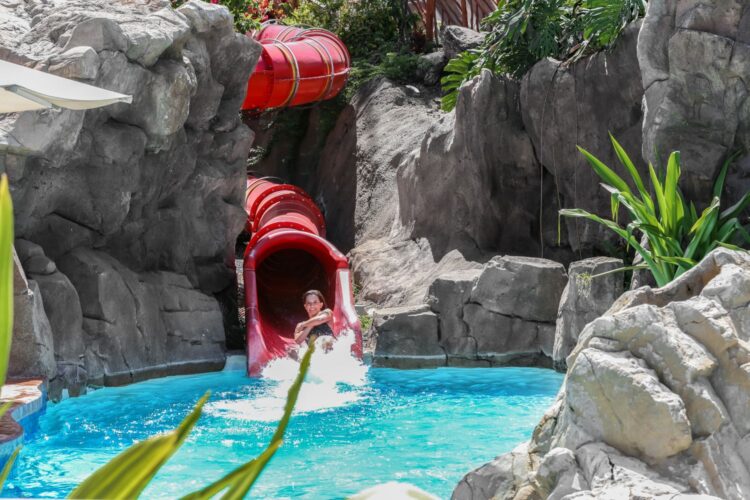 Teen enjoying water slide at Grand Wailea resort – luxury family vacation in Maui for teenagers