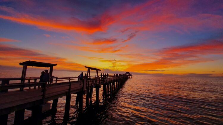 Naples Florida pier at sunset over the Gulf of Mexico — luxury beach family vacation on the Gulf Coast