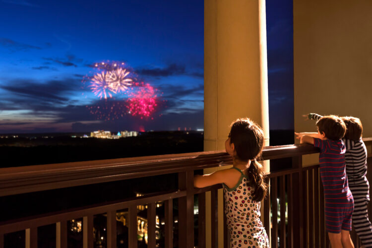 Children watching fireworks from a balcony at Four Seasons Orlando during a luxury family holiday experience.