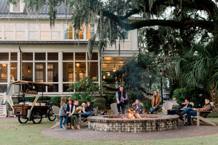 Multi-generational family enjoying a luxury holiday by the fire pit at Montage Palmetto Bluff, ideal for upscale family vacations.