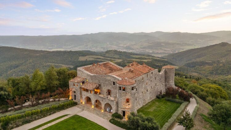 Luxury stone villa rental in Tuscany surrounded by rolling hills and scenic countryside.