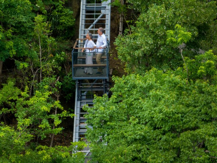 Funicular car winding through lush tropical trees at Secret Bay, Dominica, providing a scenic link from the cliffside villas down to the secluded beach.