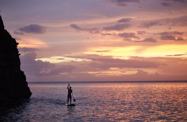 Secret Bay Dominica luxury resort paddleboarding at sunset