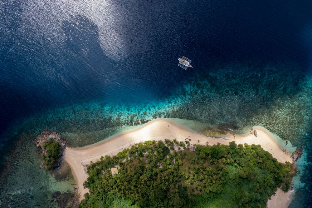 Aerial view of a private island with white sand beaches and calm turquoise waters, offering uninterrupted seclusion