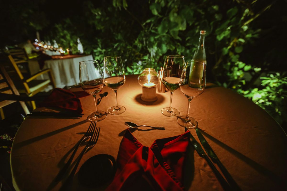 Intimate candlelit dinner table set outdoors for a private celebration