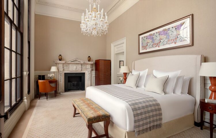 Elegant suite bedroom at Raffles London at The OWO with fireplace, high ceilings, and classic detailing