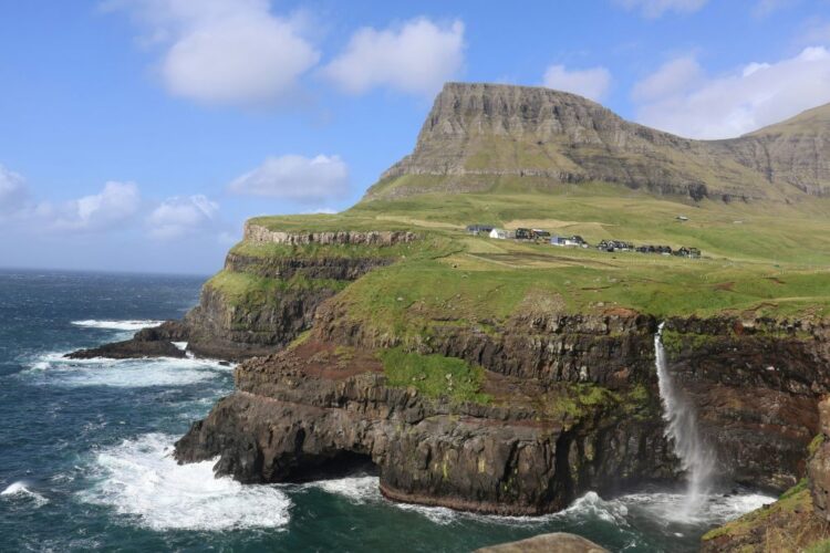 best places to travel in August — Faroe Islands Gásadalur waterfall dropping into Atlantic Ocean village clifftop Vágar island