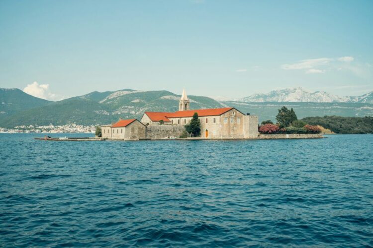 best places to travel in August — Montenegro Bay of Kotor Our Lady of the Rocks island church Adriatic mountains
