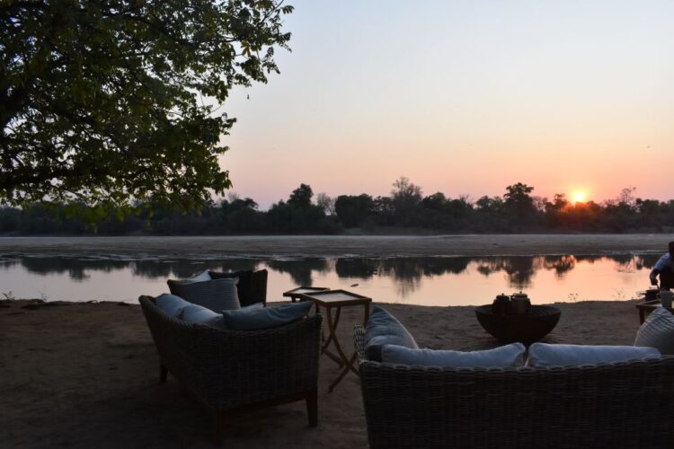 Luxury safari camp overlooking the river at sunset in Zambia