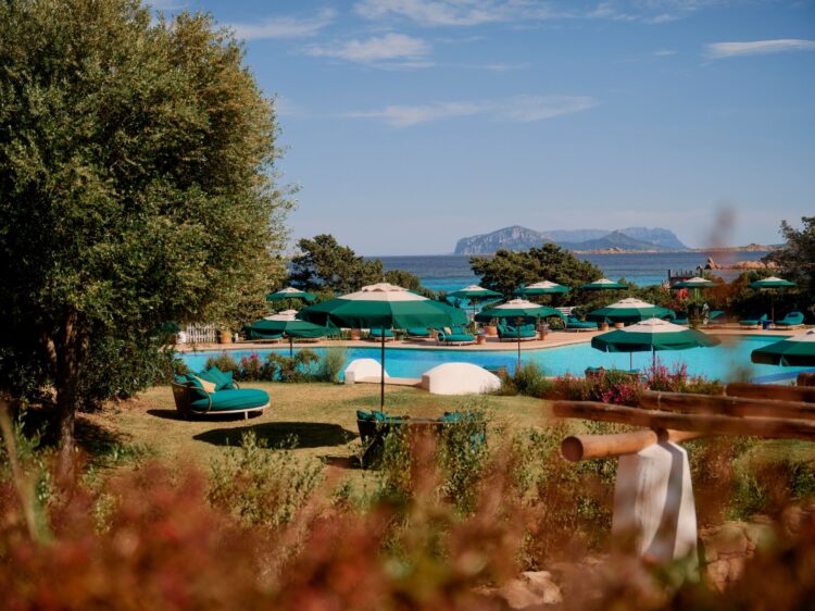 The pool at Romazzino, A Belmond Hotel, with Costa Smeralda coastline and distant island
